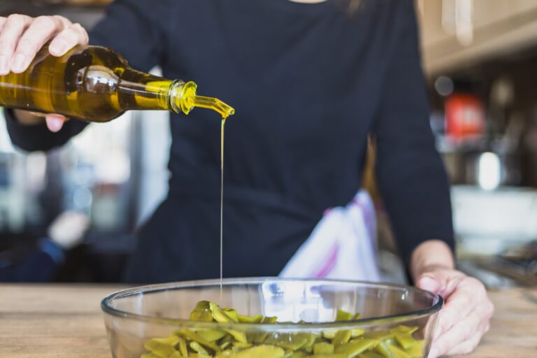 colheita-de-maos-de-mulher-cozinhar-salada-na-cozinha